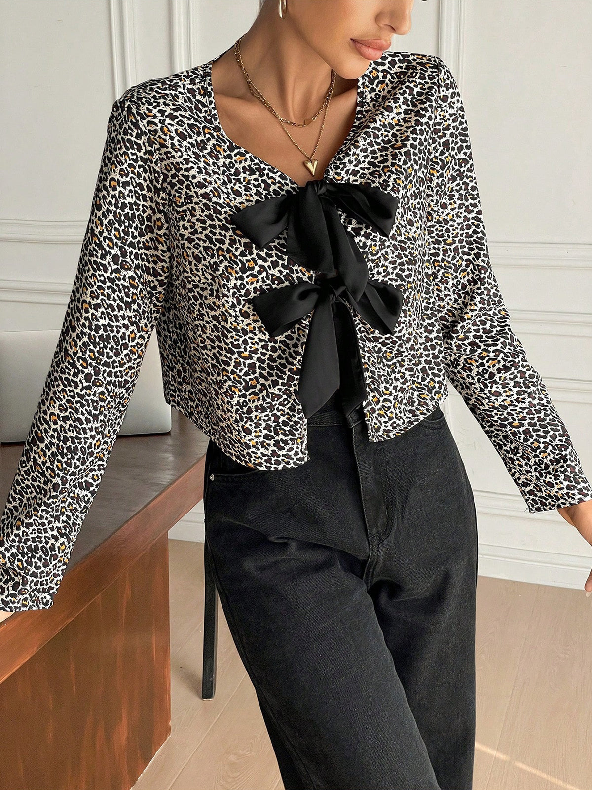 Blouse en jersey imprimé léopard avec nœud sur le devant, ornée d'un nœud papillon. Chemisier en jersey imprimé léopard avec nœud papillon.